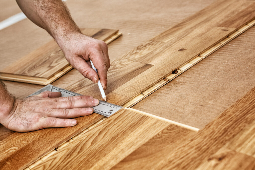 a flooring fitter installing an engineered wood floor