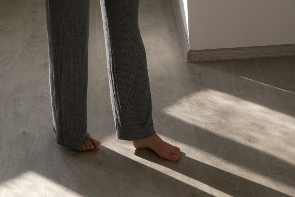 a homeowner walking barefoot on vinyl flooring with underfloor heating