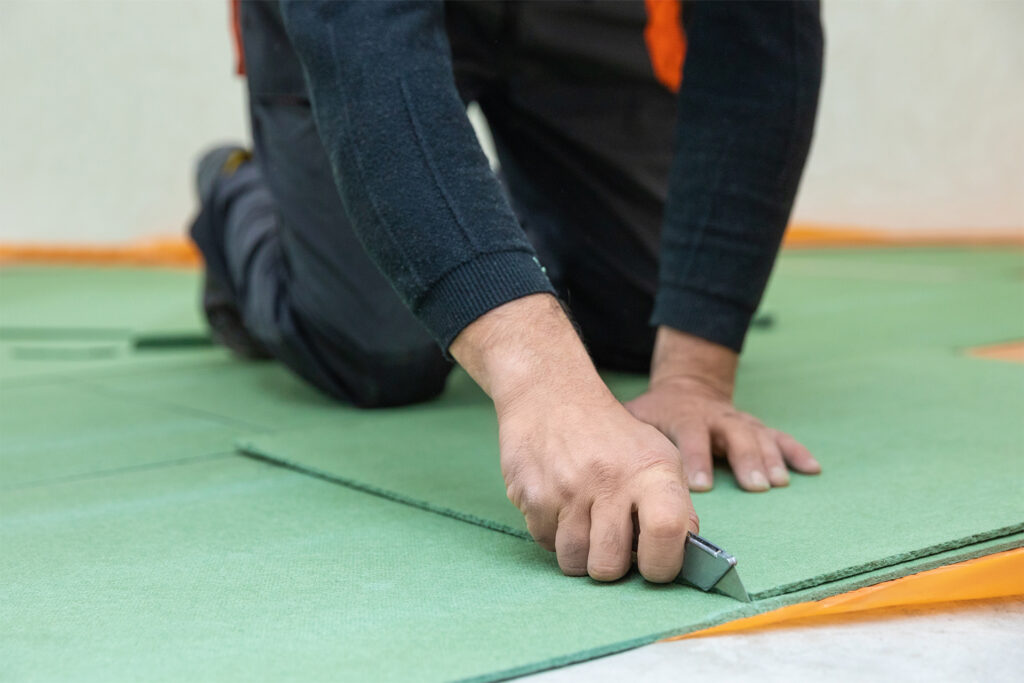 a local flooring fitter cutting underlay for a laminate floor