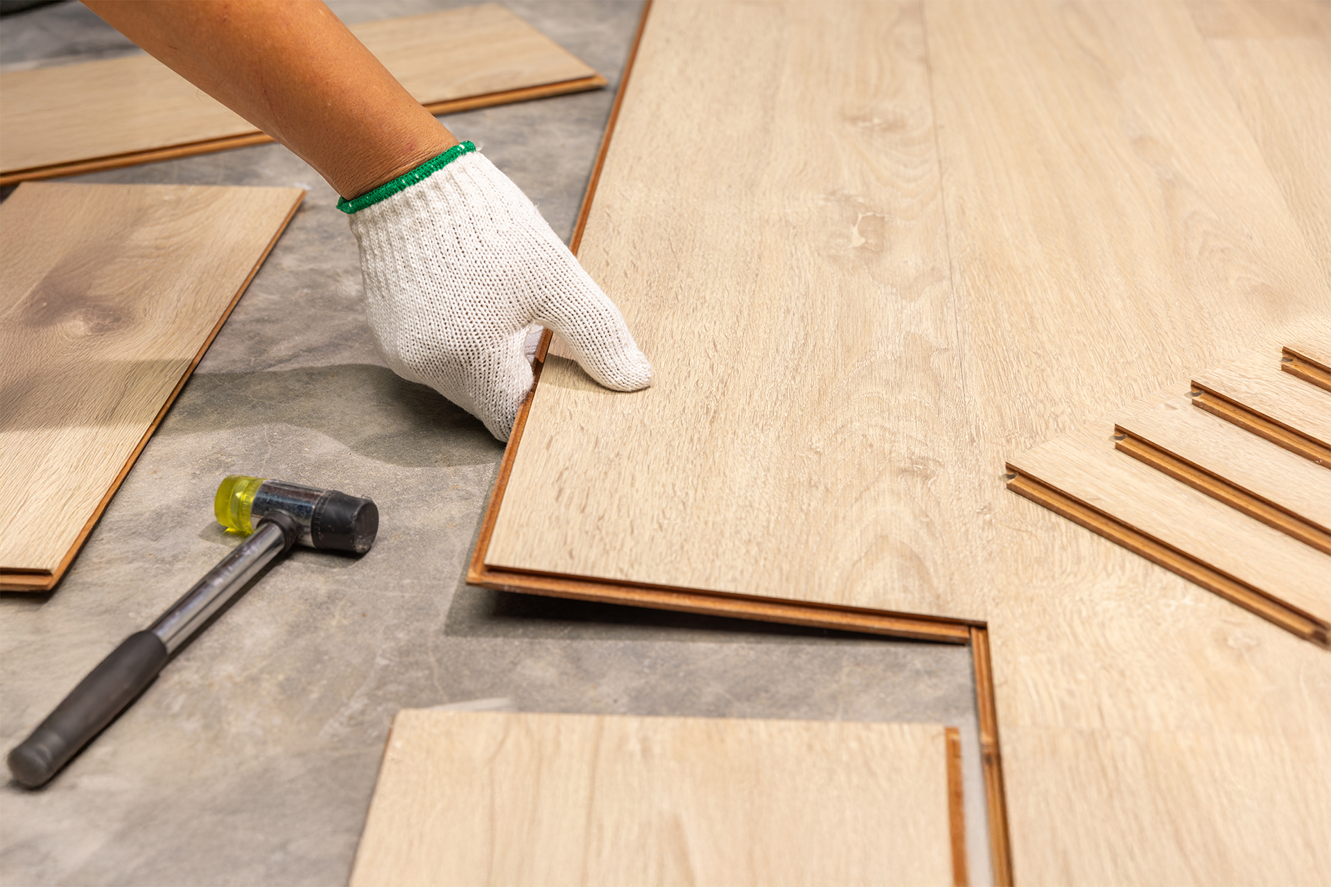 a close up demonstration of how to lay laminate flooring on concrete