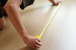 a homeowner demonstrating how to measure a room for flooring